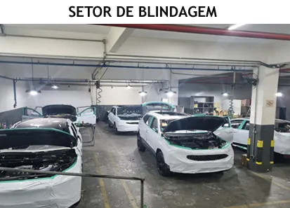 Setor de blindagem da V-TECH, com vários veículos protegidos e desmontados para receber o material balístico